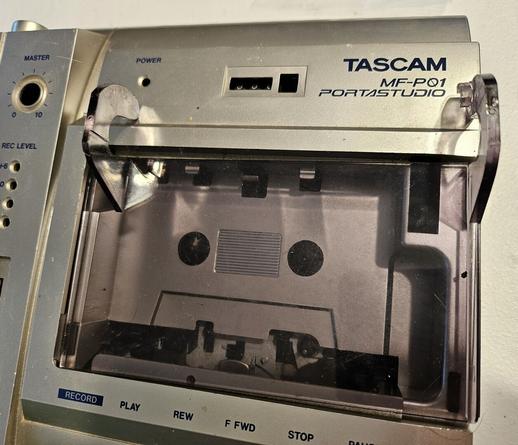 Closeup of the case to a disassembled TASCAM MF-P01. This photo is closer, focused on the tinted cassette door - flipped inside out for cleaning.