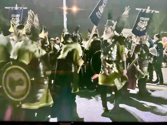 Valokuva Up Helly Aa -tapahtumasta. Kuvassa näkyy joukko viikinkimäisittäin (tosin siivekkäisiin kypäriin) pukeutuneita miehiä, joilla on kilpiä, viirejä ja yhdellä miehellä iso kirves.