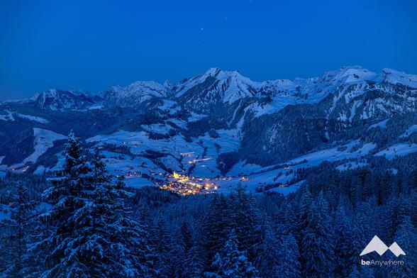 Village glowing golden in the dark of the night in the mountains