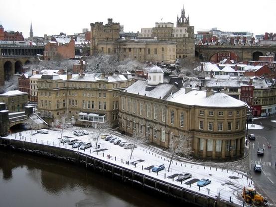 A cityscape next to a river, streets and roofs dusted with snow. The view is essentially Georgian and Victorian, with little evidence of 20th century construction