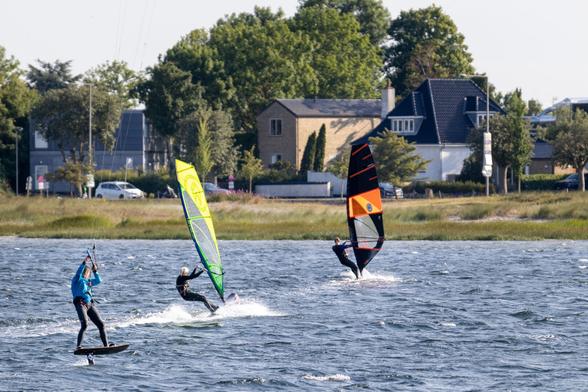 Ein Foto mit zwei Windsurfern und einem Kite-Surfer.