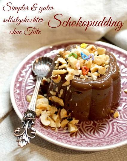 Teller auf dem ein Schokoladenpudding in Mini-Gugelhupfform ruht. Links daneben liegt ein Löffel auf dem Teller. Vom Pudding herunter sieht eins grob gehackte Nussstücke herunterrieseln, ein paar bunte Zuckerherzen sind auch darüber gestreut. Oben steht in geschwungener Schrift "Simpler & guter Schokopudding - ohne Tüte"