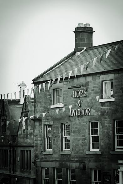 Front elevation of the Hope & Anchor pub; the pub's name is visible as a sign near the top of the building; bunting flies in front.