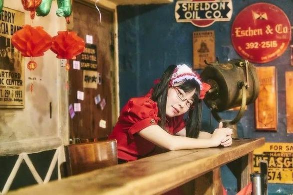 Menma in her Melon Batake outfit sits at a counter in a room decorated with retro signs. Yellow tinted.