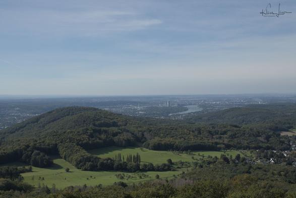 Das Foto zeigt eine spätsommerliche Landschaftsaufnahme der Kölner Bucht mit Blick auf den Stenzelberg,, Bonn, Teile der Voreifel und in der Ferne Köln, aufgenommen vom Ölberg im Siebengebirge.
