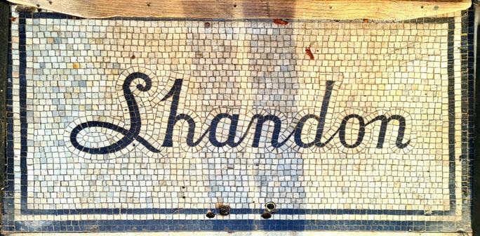 A theshold mosaic with the word Shandon on it in joined-up writing.