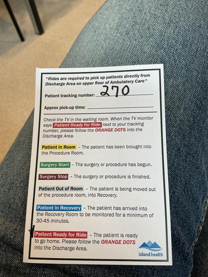 A picture of a small piece of paper sitting on my leg. It has the number 270 at the top and underneath there are six stages in different colours from patient in room to patient ready for ride.