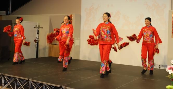 Quatre danseuses portant la même tenue chinoise rouge dansent sur une scène.
(photo : www.gouvenelstudio.com)
