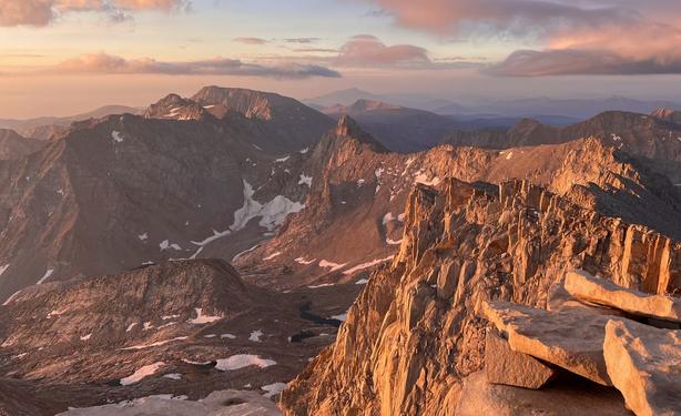 Early morning light casting and reflecting warm colors on the cliffs of high alpine mountains