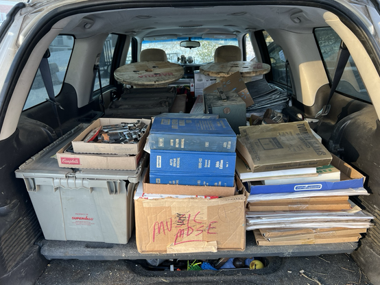 A car full of automotive books, literature, and collectibles from an auction.