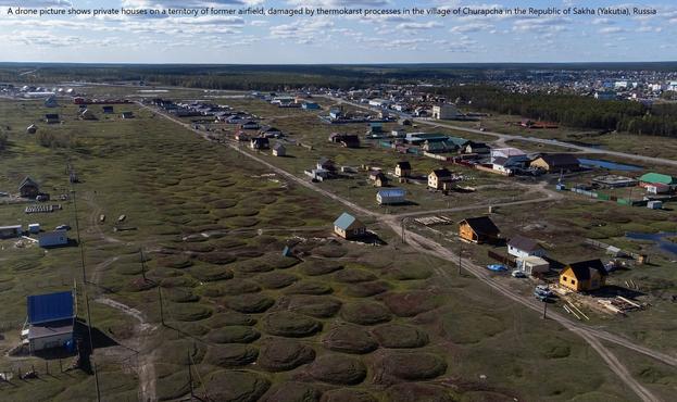 photo - A drone picture shows private houses on a territory of former airfield, damaged by thermokarst processes in the village of Churapcha in the Republic of Sakha (Yakutia), Russia September 5, 2021