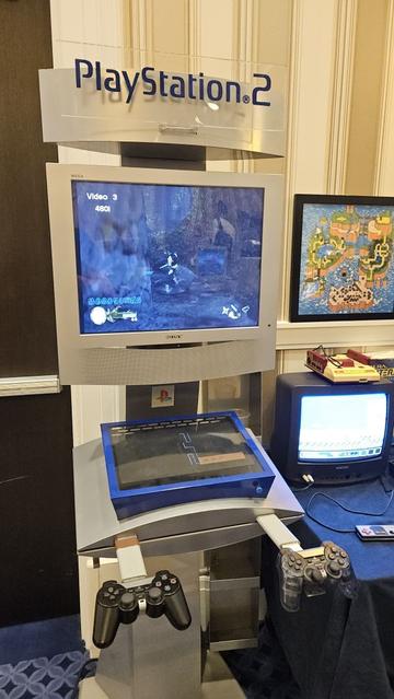 An in-store stand-up display unit of a playable PlayStation 2 with two controllers attached.