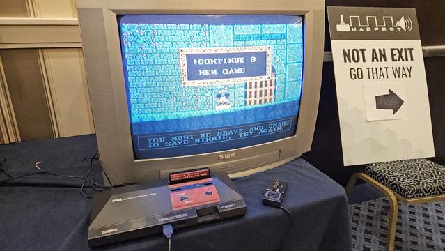 A Sega Master System with a Mickey Mouse game on the screen.