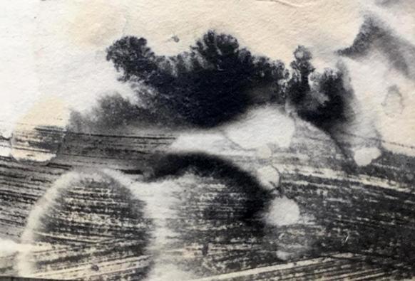 C'est un petit fragment de papier Xuan teint avec du thé et portant des marques  d'encre de Chine.  La moitié inférieure de l'image porte une trace de pinceau large allant de gauche à droite, infiltrée de marbrures de la couleur du papier et faisant un angle aigu vers la gauche avant de sortir du fragment.  Des marques ovoîdes entrecoupent le trait et dessinent des passages . Sur le haut de l'image se déploient trois taches : une petite blanche , d'où part une seconde plus grande, noire au centre aux contours trés découpés et une toisième plus légère et grise en haut à droite.
l'ensemble évoque un paysage mystérieux, indécis, brumeux...