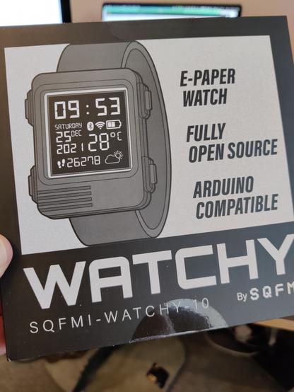 Me holding a (so far unopened) box containing the SQFMI Watchy kit. This is an open source watch based on an ESP32 processor and an e-ink display. Yes it's Big Person's Toys but I'm an adult and I want my toys, damn it!