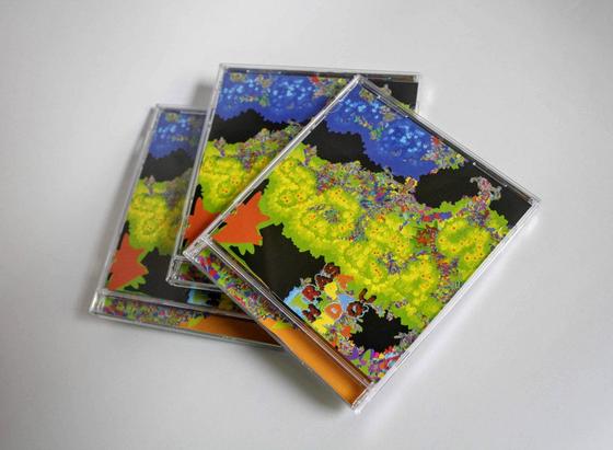 a stack of CD jewel cases with a colorful, bubbly procedural art cover design in shades of neon green, blue, and orange on a black background