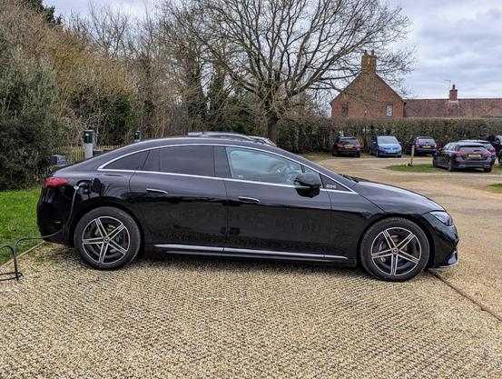 Photo of a Mercedes EQE 350+ electric sedan car from the side.