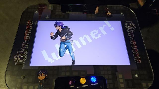 A tabletop arcade machine called Oshi-Gokko showing the winner screen. I was not the winner.
