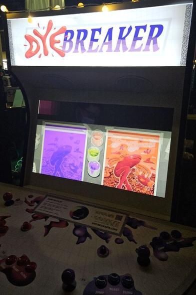 A standup arcade machine called Dye Breaker. On the screen are two screenprinted frogs. The red one on the right is painted in more.