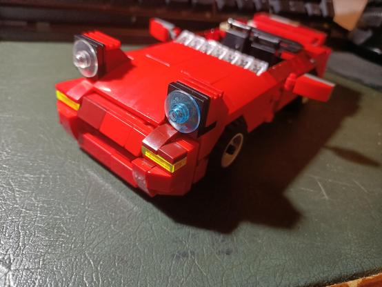 Another picture of the LEGO MX-5 taken from a more 'bird's eye view' perspective. The front, left side, and top are all visible. A bit of the interior can be seen.