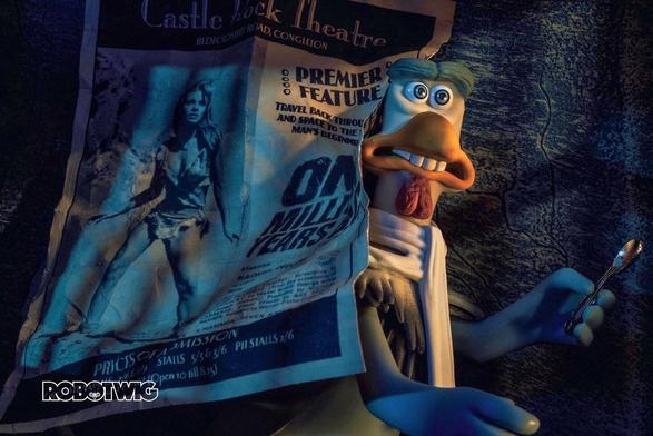 Fowler appears from behind a news paper clipping stuck to the wall with a spoon in his hand. Clipping says Castle Rock Theatre and has a movie showing of One Million Years BC