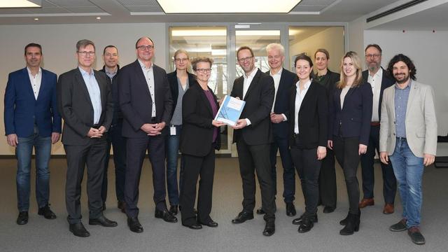 Foto der Übergabe des Planfeststellungsbeschlusses zwischen der Bundesnetzagentur und dem Vorhabenträger Amprion.