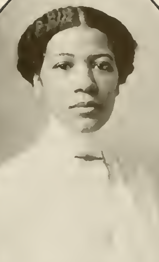 Ethel M. Caution-Davis, from the 1912 yearbook of Wellesley College; a young Black woman with hair parted center and dressed to the nape, wearing a white blouse with a high collar