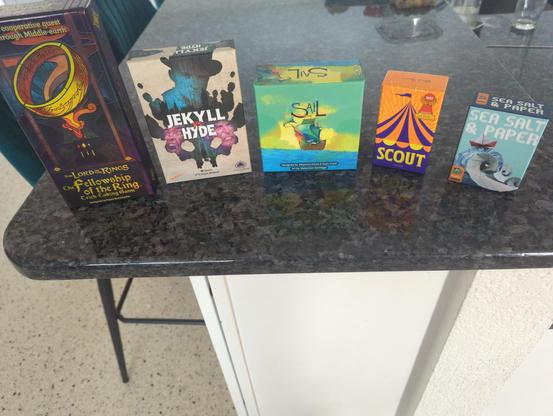 Five card game boxes on my kitchen counter:

- The Lord of the Rings The Fellowship of the Rings Trick Taking Game
- Jekyll vs Hyde
- Sail
- Scout
- Sea Salt & Paper