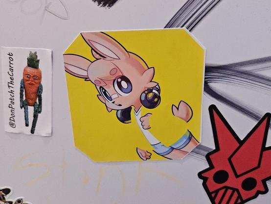 Several stickers. The middle one is of a pink bunny rabbit with headphones around its neck.