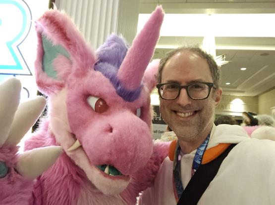 A person in a Nidorino fursuit stands next to a slightly balding man in a Scorbunny kigurumi.