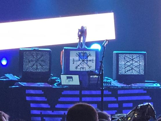 Three CRT monitors on a table, Mobile Suit Gundam model on top of the center. Under the left and right monitors are Commodore computers.