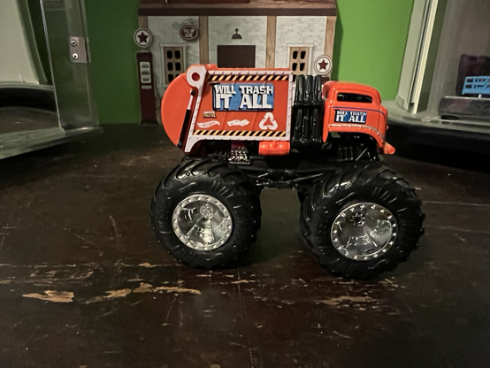 An orange monster truck toy called Trash it All made by HotWheels.