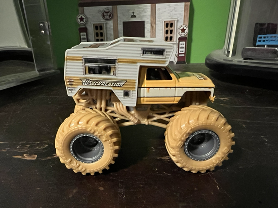 A yellow and white monster truck toy called Wreckreation made by HotWheels.