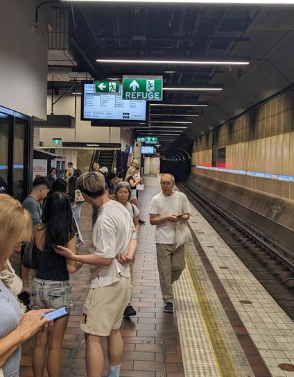 photo of two emergency exit signs blocking the view of train departure screens at Melbourne Central Station