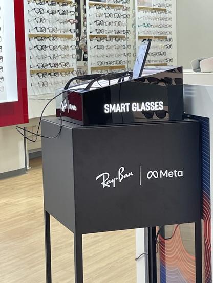 Ray ban and meta stand in eye wear shop. advertising “smart glasses”. same ones mark was wearing.