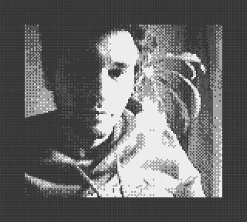 Selfie of a dude sitting near a window, with one side of the face in shadow, one in bright light, highly pixelated