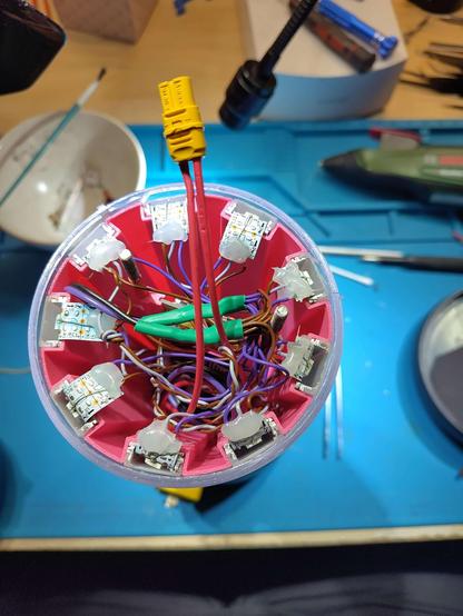 lot of cables connected to led stripes inside of the opened camping lamp.