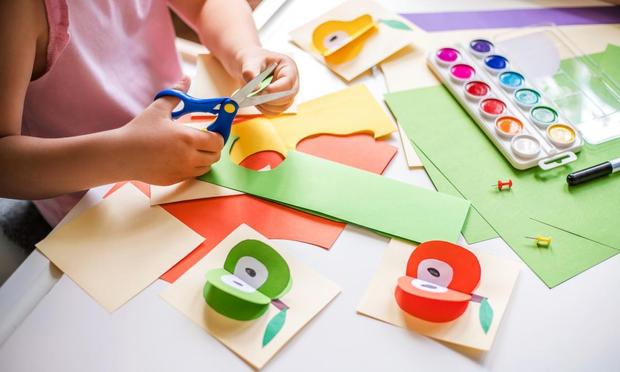 Una niña pequeña haciendo manualidades en el colegio. (Getty Images)