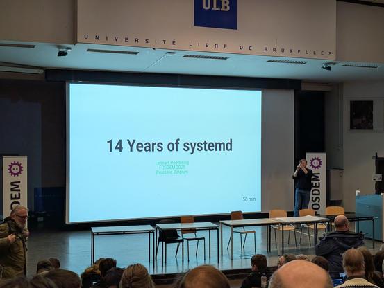 Lennart Poettering taking a panoramic photo of the room before his keynote talk, 14 Years of systemd