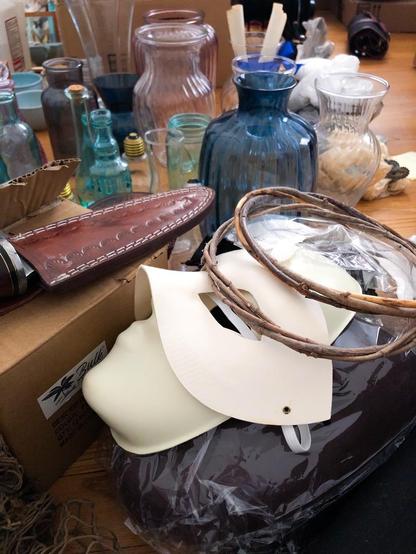 Pile of conceptual photography props, including masks, vases, and twisted twig crowns.