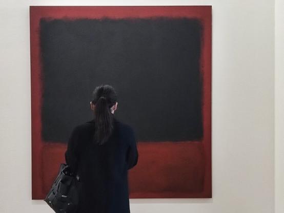 The third image of a series of three shots in a row where we see two women alternately taking a photo of a painting in a museum. This shot is the final image, before it is framed and edited. With only the final image, we would know nothing about the fact that she had taken a photograph before she became the subject of that picture, and that she was doing the same thing as someone before her.