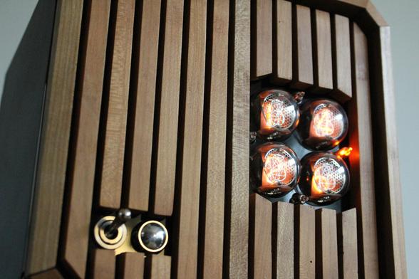 Photograph of the nixie clock, facing right, showcasint more the on-off lever switch and chromed button