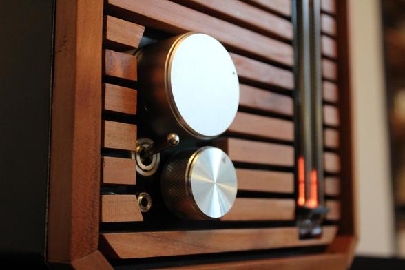 Close-up shot of the nixie amplifier from the left side, focusing on the metal knobs, power switch and input jack