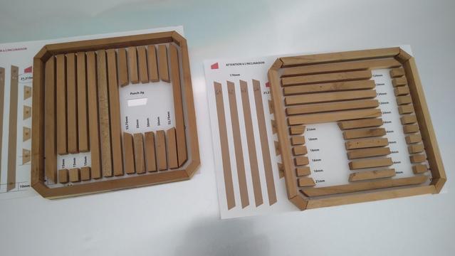 All the wooden parts of the projects façades layed down on sheets of paper that have the cutting instructions printed on them