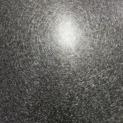 This is a monochrome image of light reflected off a brushed aluminum surface.