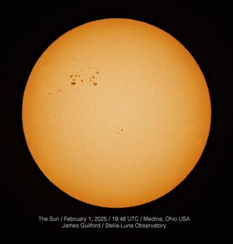 An image of the solar disk showing a group of sunspots at about the 10 o'clock position. First image in monochrome, second image with false color applied.