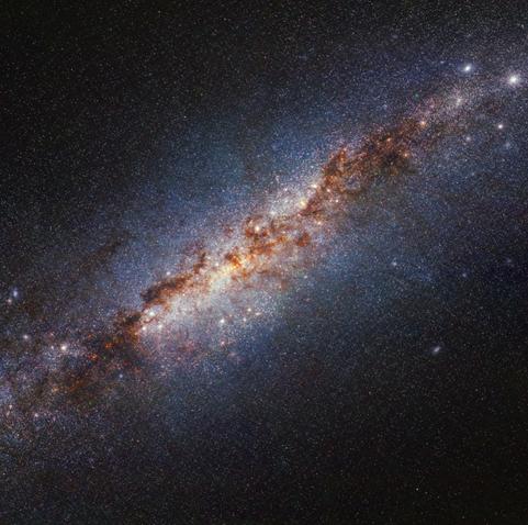 Image of the starburst galaxy M82 from the JWST. Bright stars and dust is visible from the bottom left to top right. The top left and bottom right corners are dark.