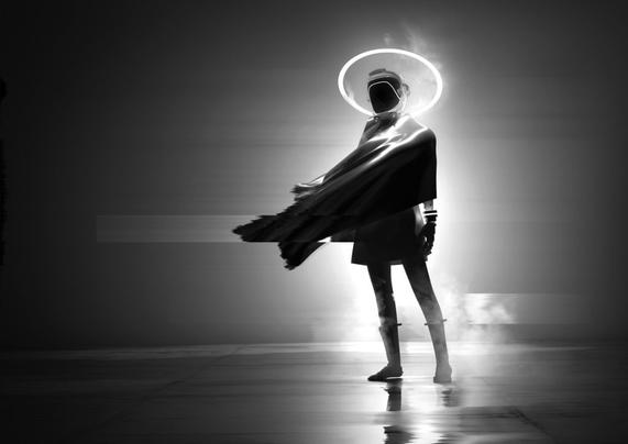 Black and white siloette of a female figure in an astronaut suite with a space helmet and halo around it