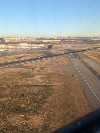 A photo taken from a November 2021 departure from National Airport shows Runway 33 below, with the northern end of National's concourses and the Pentagon visible beyond it.