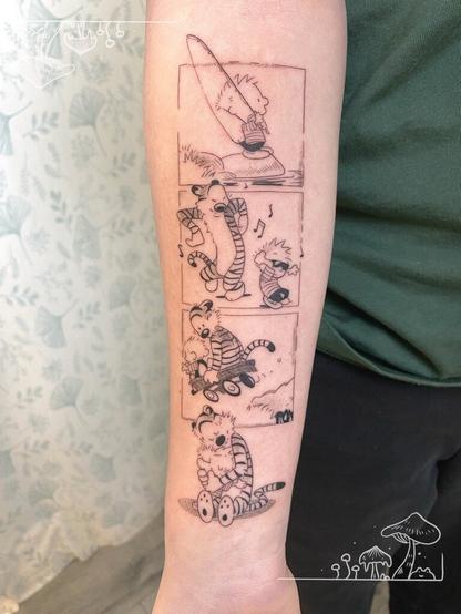 An arm tattoo depicting four panels from Calvin & Hobbes